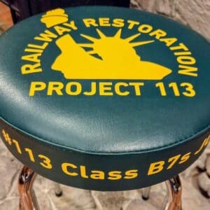 Green barstool seat with yellow restoration logo