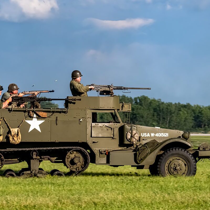 Soldiers firing from World War II half-track
